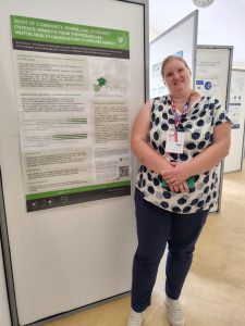 Dr. Ana Slavec standing by the poster